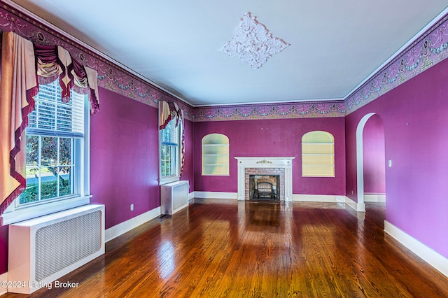 unfurnished living room with dark hardwood / wood-style floors, plenty of natural light, and a brick fireplace