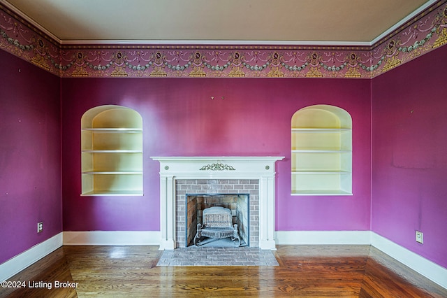 unfurnished living room with ornamental molding, wood-type flooring, a fireplace, and built in shelves