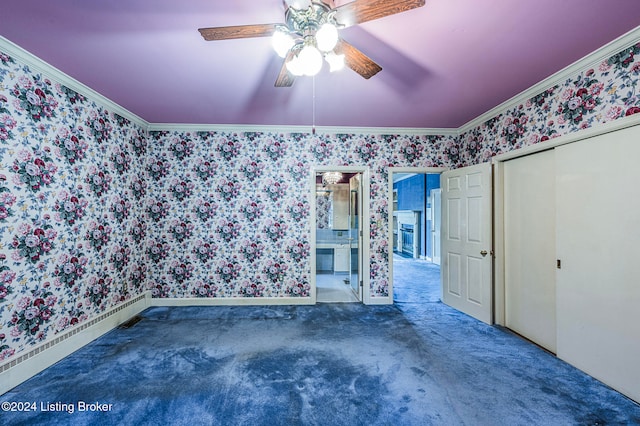 unfurnished bedroom featuring dark carpet, crown molding, a closet, and ceiling fan