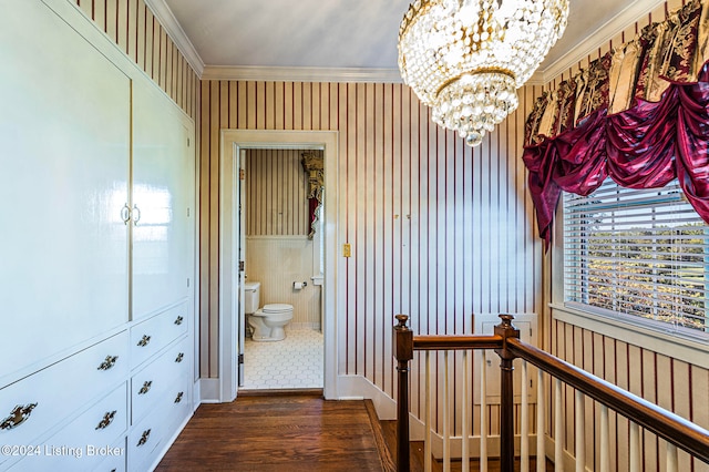 corridor with crown molding, dark hardwood / wood-style flooring, and a chandelier