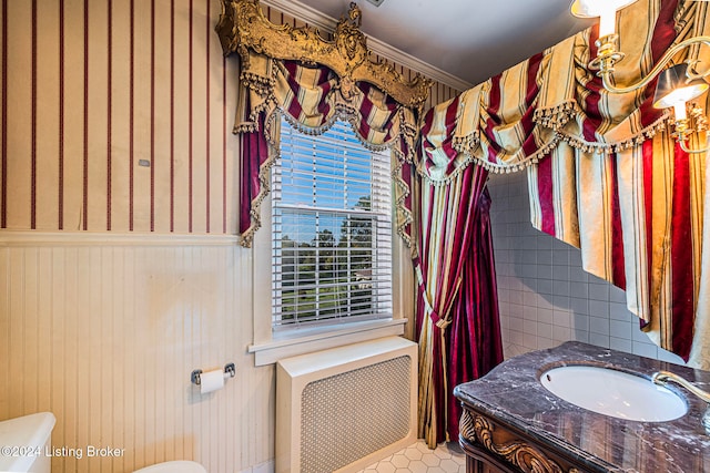 bathroom featuring toilet, ornamental molding, and vanity