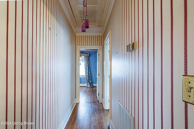 corridor with crown molding, hardwood / wood-style floors, and wooden walls