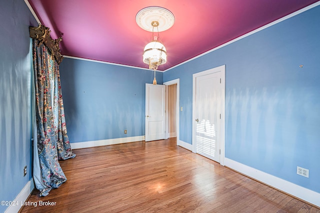 unfurnished bedroom featuring ornamental molding and hardwood / wood-style floors