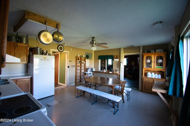 kitchen with ceiling fan, a textured ceiling, white appliances, and extractor fan