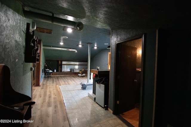 corridor with lofted ceiling and light hardwood / wood-style flooring