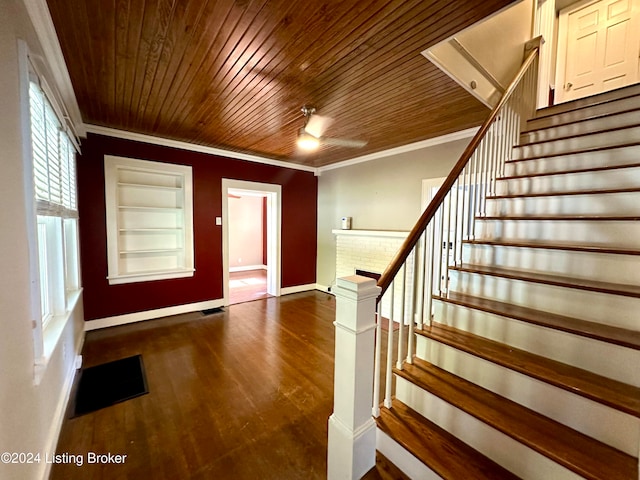 foyer with dark wood-type flooring, wood ceiling, and ornamental molding