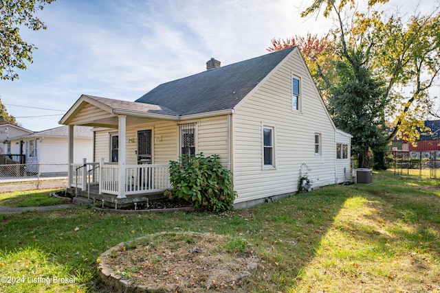 view of front of home featuring a front lawn, central AC, and a wooden deck