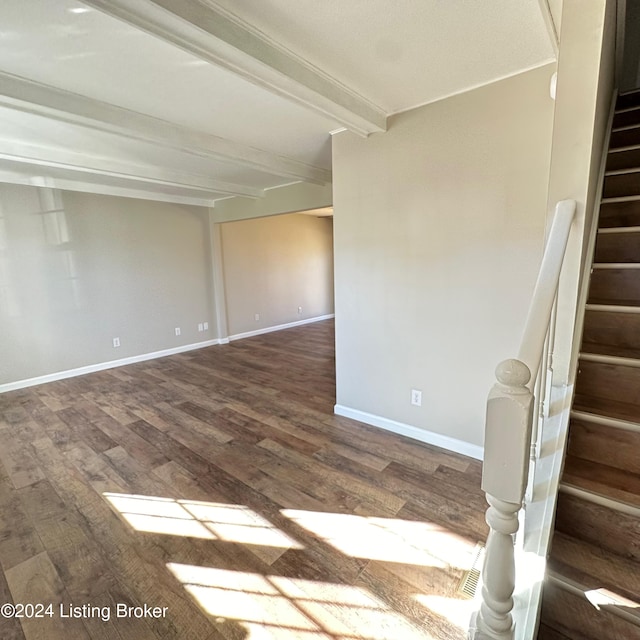 spare room featuring hardwood / wood-style floors and beamed ceiling