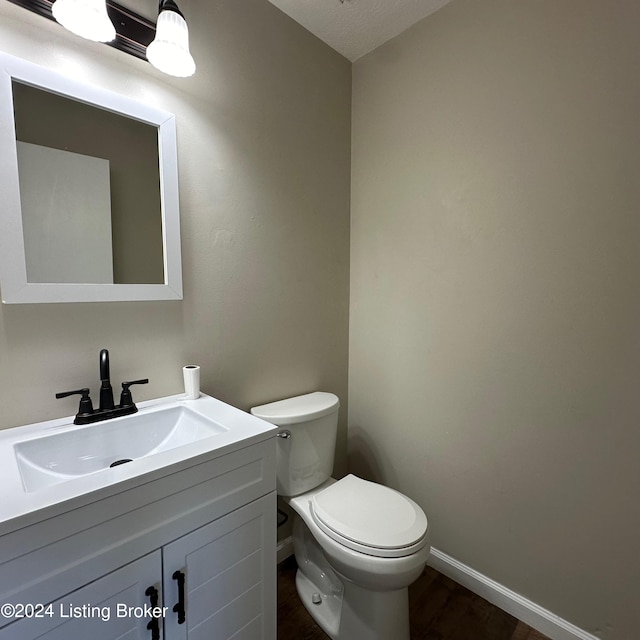 bathroom featuring toilet, vanity, and a textured ceiling