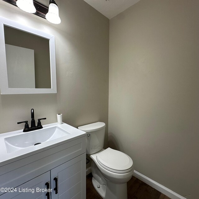 744 Brian Ct, Radcliff, KY 40160 - bathroom featuring baseboards, vanity, toilet, and wood finished floors
