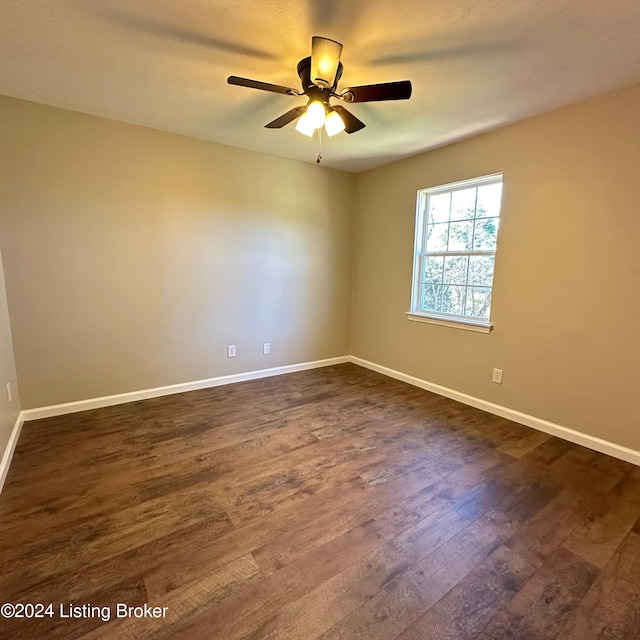 empty room with dark wood-type flooring and ceiling fan