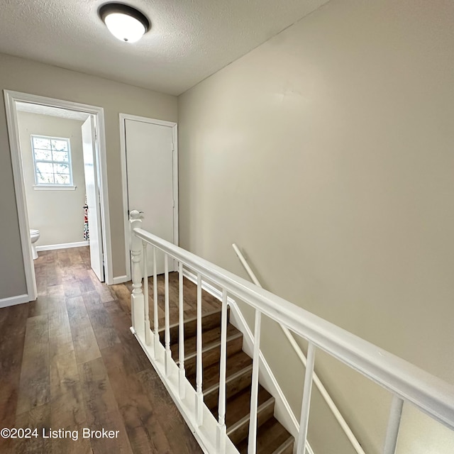 744 Brian Ct, Radcliff, KY 40160 - hallway featuring dark wood finished floors, a textured ceiling, baseboards, and an upstairs landing