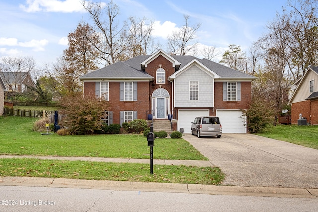 raised ranch with cooling unit, a garage, and a front yard