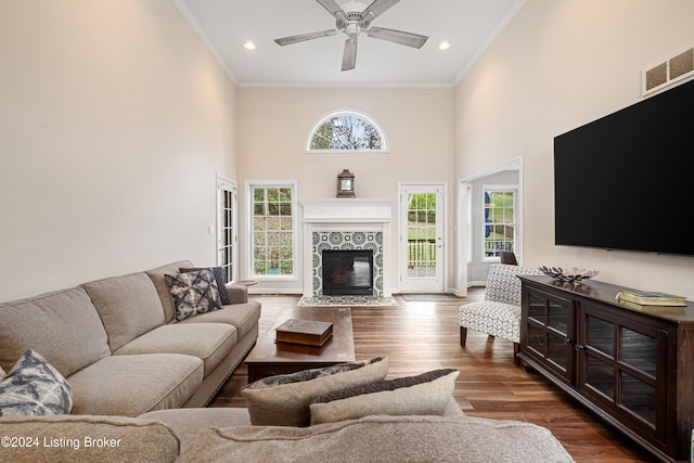 living room featuring crown molding, dark hardwood / wood-style flooring, and a healthy amount of sunlight