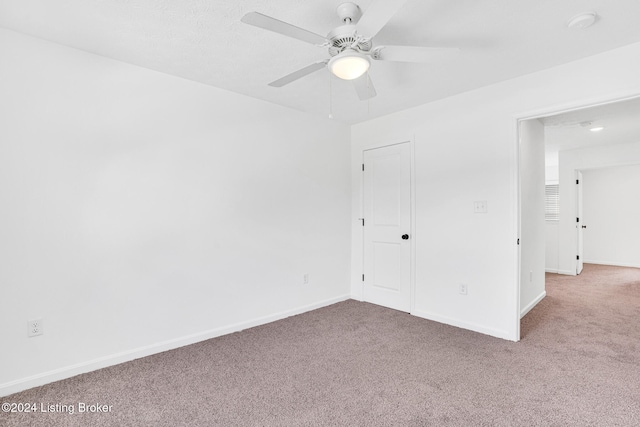 empty room featuring light carpet and ceiling fan