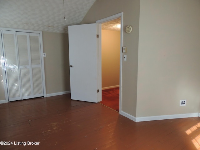 empty room featuring hardwood / wood-style floors and lofted ceiling