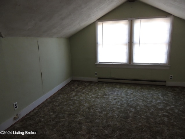 bonus room with vaulted ceiling, dark carpet, and a baseboard heating unit