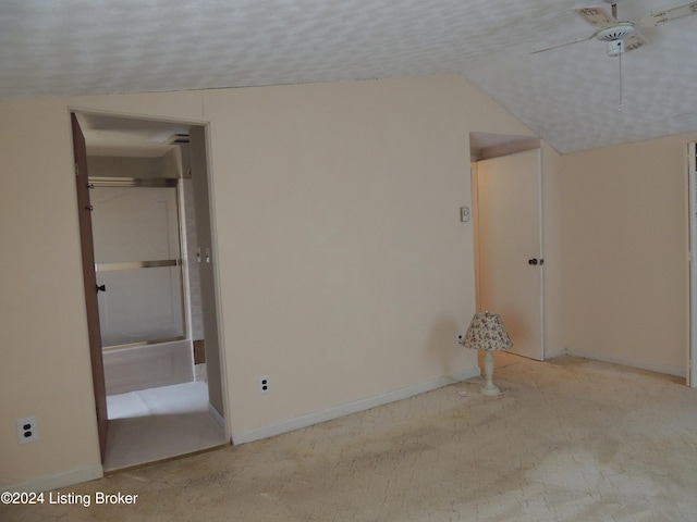 interior space with ceiling fan, lofted ceiling, and a textured ceiling