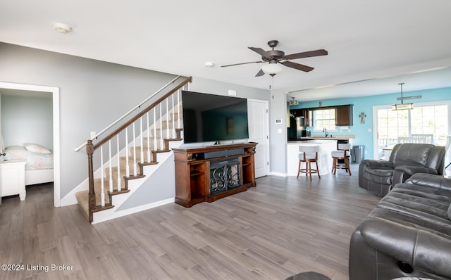 living room featuring hardwood / wood-style flooring, sink, and ceiling fan