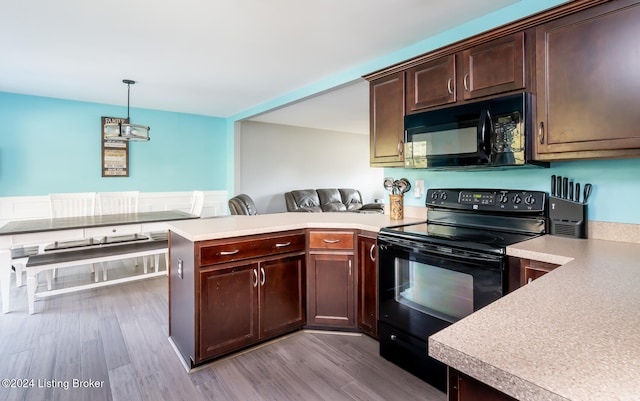 kitchen featuring black appliances, kitchen peninsula, dark brown cabinetry, decorative light fixtures, and light hardwood / wood-style flooring