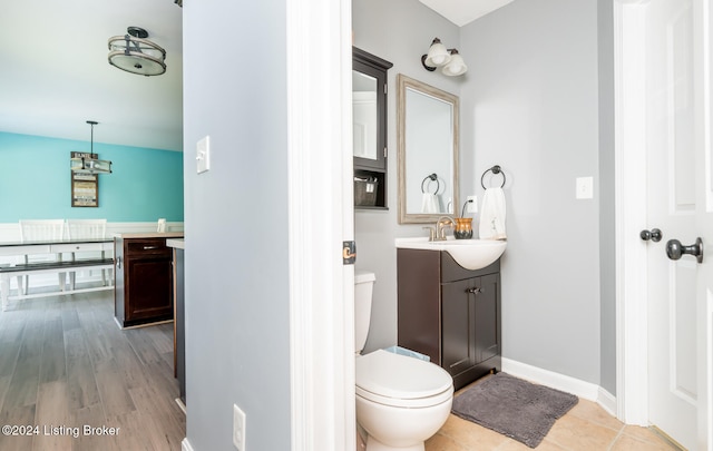 bathroom featuring toilet, hardwood / wood-style flooring, and vanity