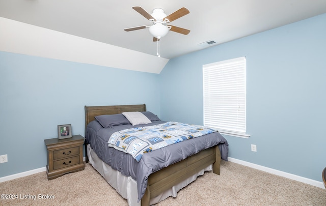 bedroom with vaulted ceiling, light colored carpet, and ceiling fan