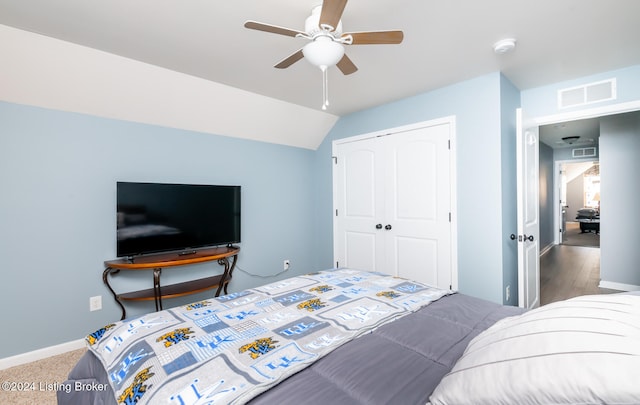 bedroom featuring hardwood / wood-style floors, vaulted ceiling, a closet, and ceiling fan