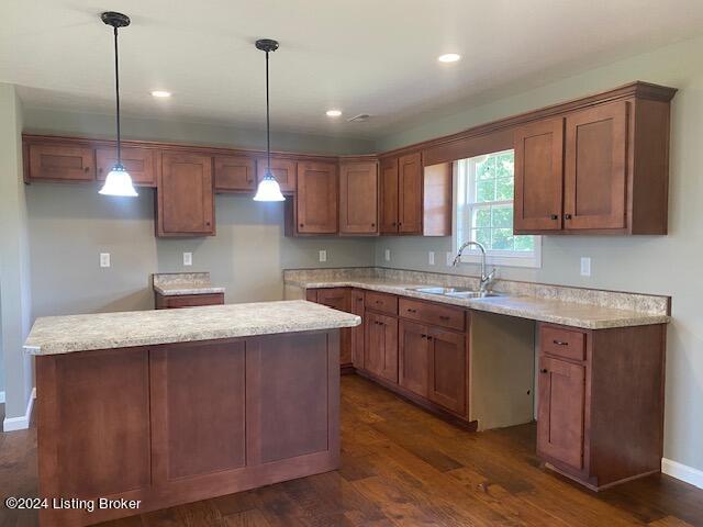 kitchen featuring a center island, sink, dark hardwood / wood-style floors, and hanging light fixtures