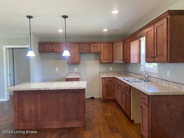 kitchen with a center island, sink, pendant lighting, and dark hardwood / wood-style flooring