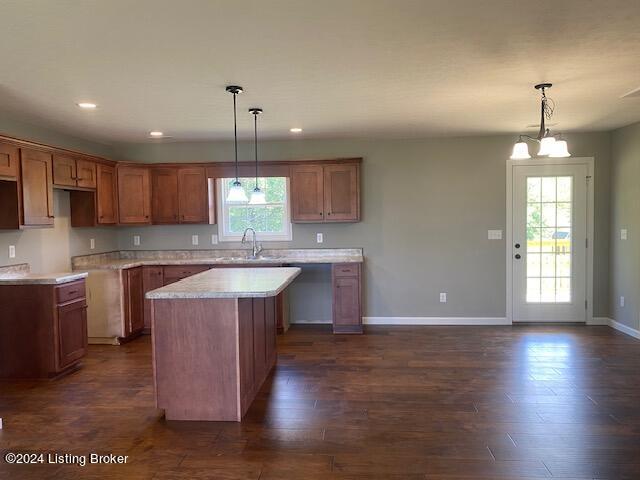 kitchen with a notable chandelier, a center island, hanging light fixtures, and dark hardwood / wood-style flooring