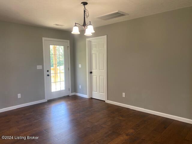 interior space featuring dark hardwood / wood-style floors and an inviting chandelier