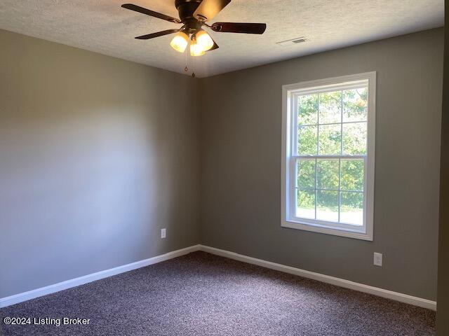 carpeted empty room with a textured ceiling and ceiling fan