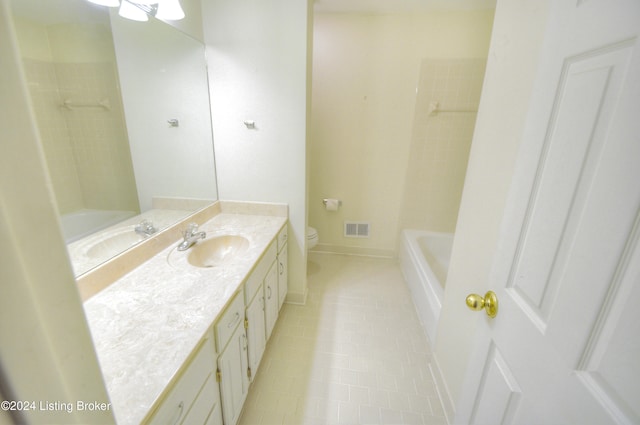 full bathroom with tile patterned floors, vanity, tiled shower / bath combo, and toilet