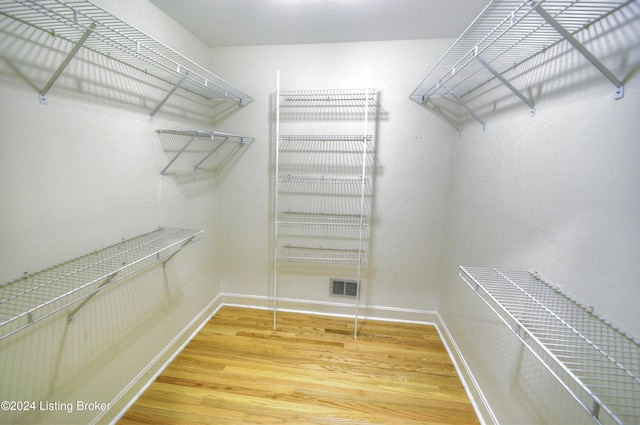 spacious closet with hardwood / wood-style flooring