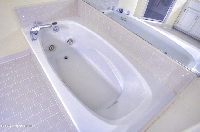 bathroom featuring tile patterned flooring and tiled bath