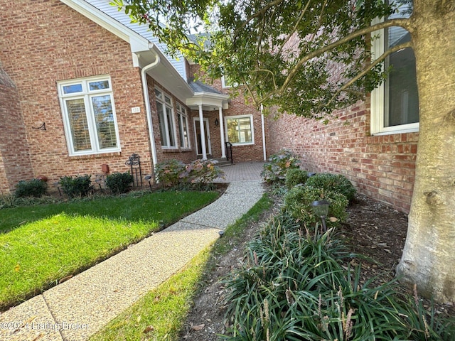 doorway to property with a lawn