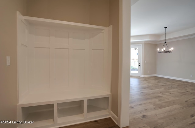 mudroom with wood-type flooring and an inviting chandelier