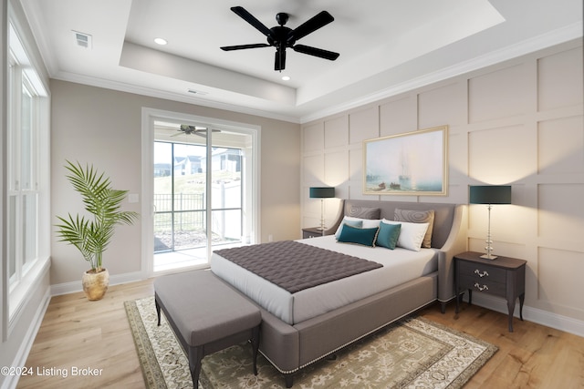 bedroom with a tray ceiling, access to exterior, ceiling fan, and light wood-type flooring