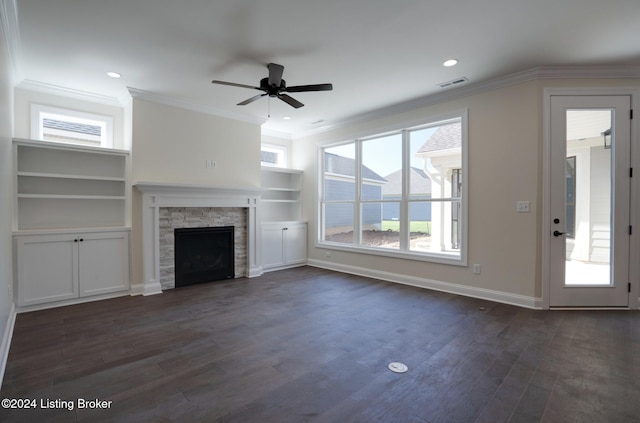 unfurnished living room featuring crown molding, a fireplace, dark wood-type flooring, and plenty of natural light