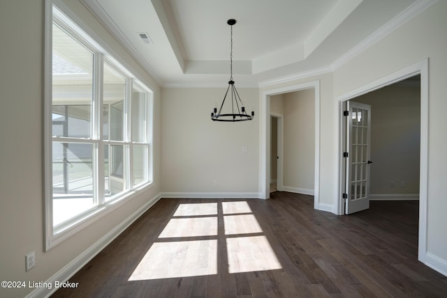 unfurnished dining area with a notable chandelier, dark hardwood / wood-style floors, a tray ceiling, and crown molding