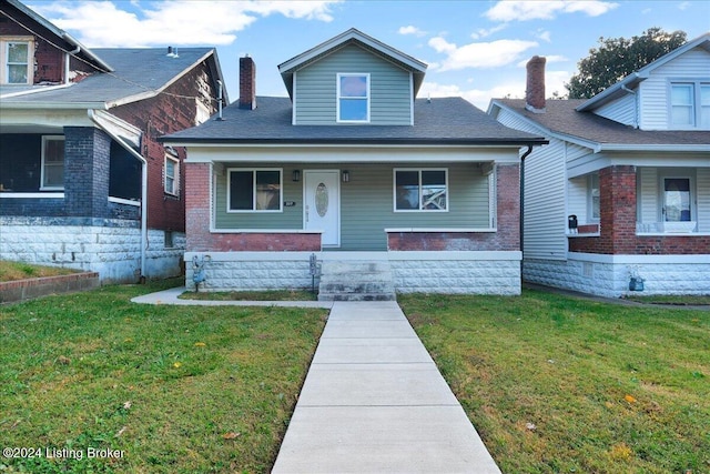 bungalow with a front lawn and covered porch