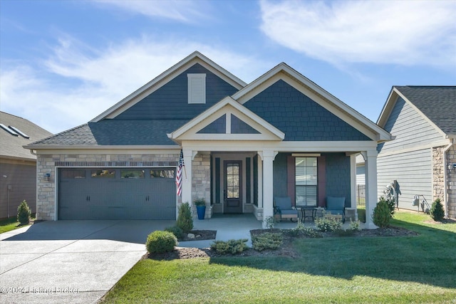 view of front of house with a front lawn, covered porch, and a garage