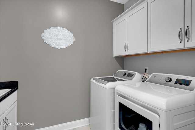 clothes washing area featuring cabinets and washing machine and clothes dryer