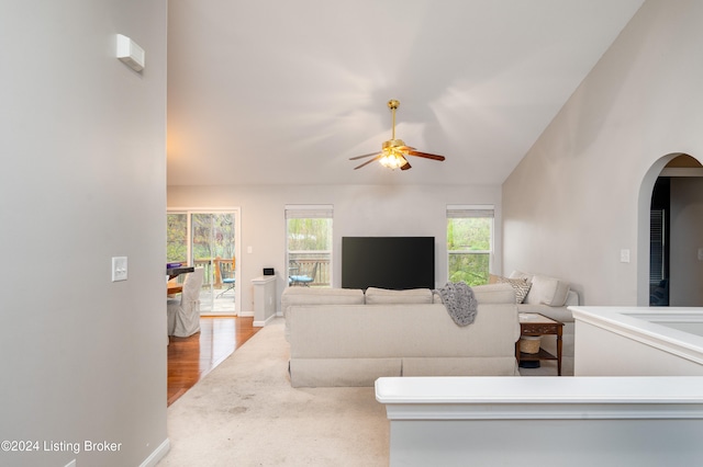 living room featuring light hardwood / wood-style floors, ceiling fan, a healthy amount of sunlight, and vaulted ceiling