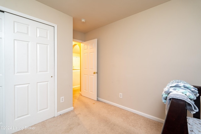 bedroom with a closet and light colored carpet