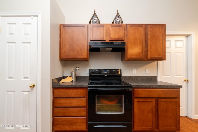 kitchen featuring black electric range oven, light hardwood / wood-style flooring, and range hood