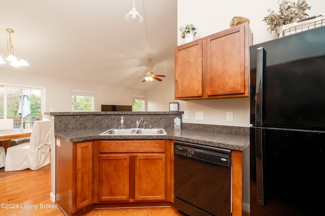 kitchen with light hardwood / wood-style floors, sink, black appliances, and decorative light fixtures