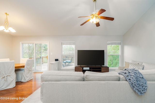 living room featuring hardwood / wood-style floors, ceiling fan with notable chandelier, a healthy amount of sunlight, and vaulted ceiling