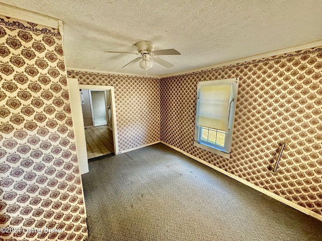 carpeted empty room with ceiling fan and a textured ceiling