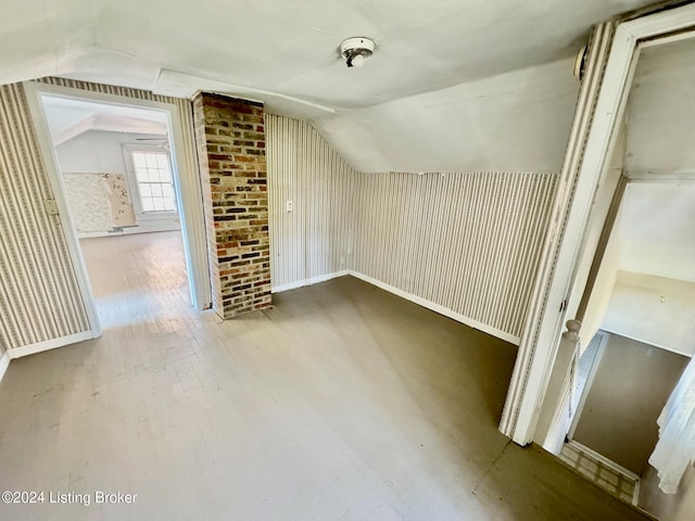 additional living space featuring hardwood / wood-style floors and vaulted ceiling